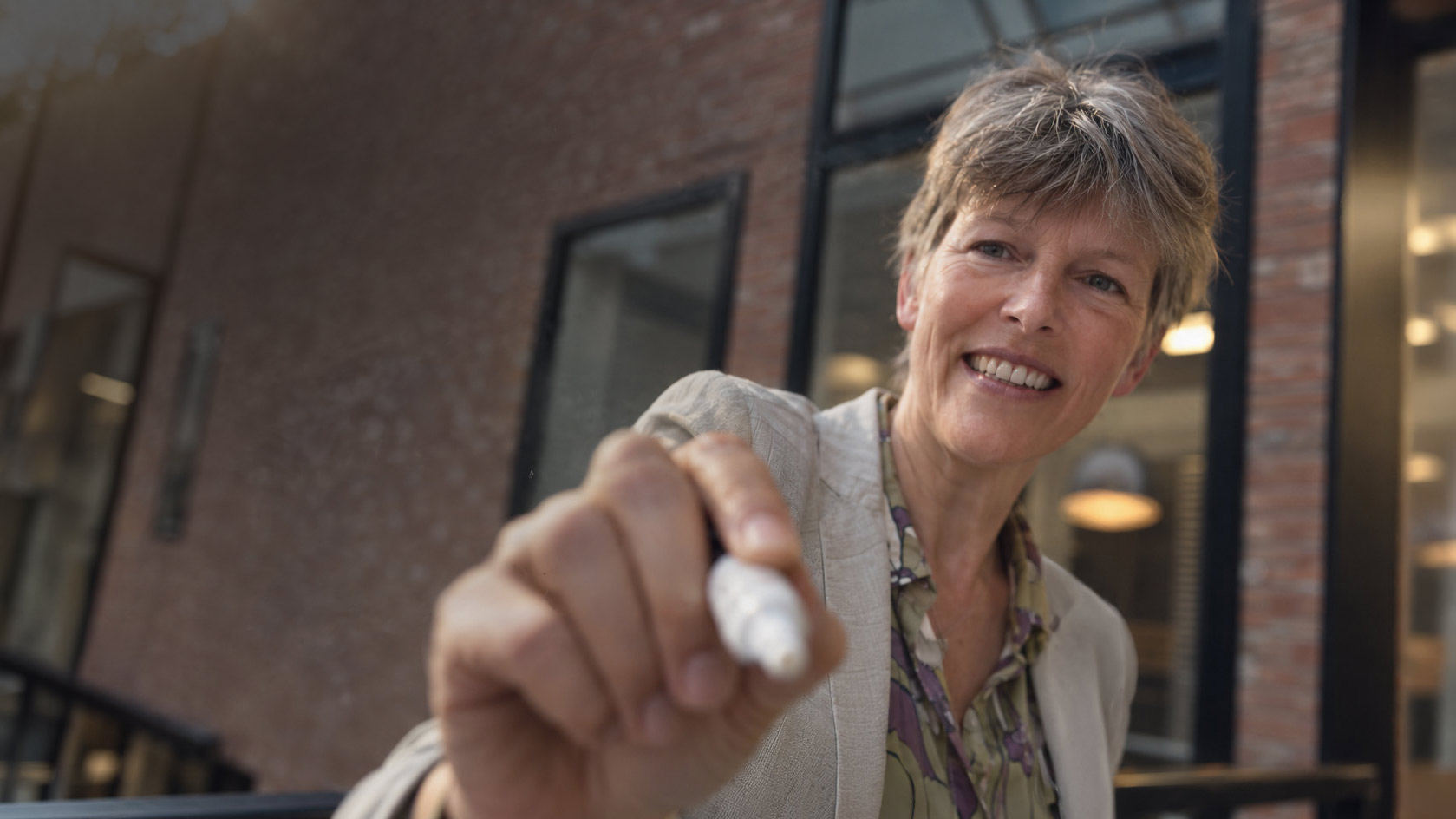 Pauline schrijft met een witte marker naar de camera